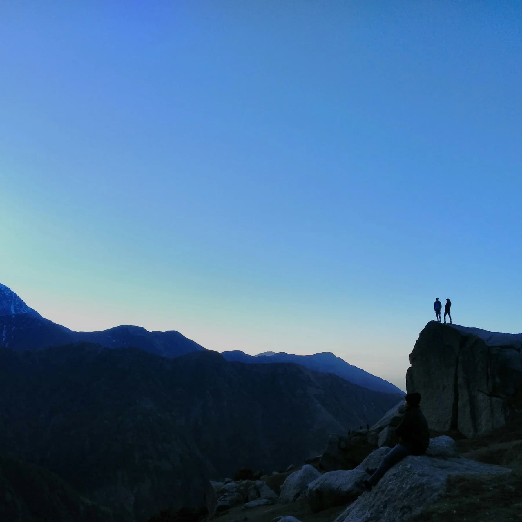 Trekkers overlooking the mountain landscape at Triund near McLeod Ganj